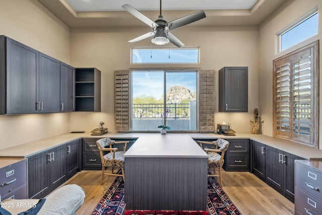 office area with plenty of natural light, built in desk, and ceiling fan