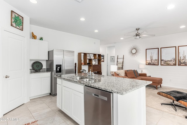 kitchen featuring stainless steel appliances, an island with sink, sink, and white cabinets