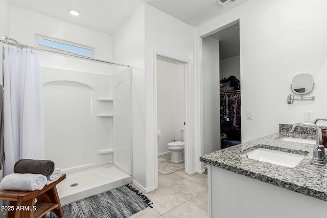 bathroom featuring vanity, toilet, curtained shower, and tile patterned flooring