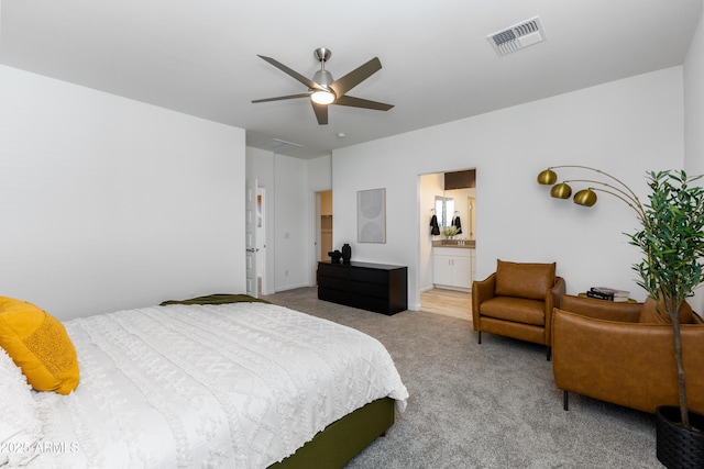 bedroom with ensuite bathroom, carpet floors, and ceiling fan