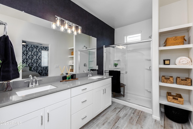 bathroom featuring hardwood / wood-style flooring, vanity, and a shower with shower door