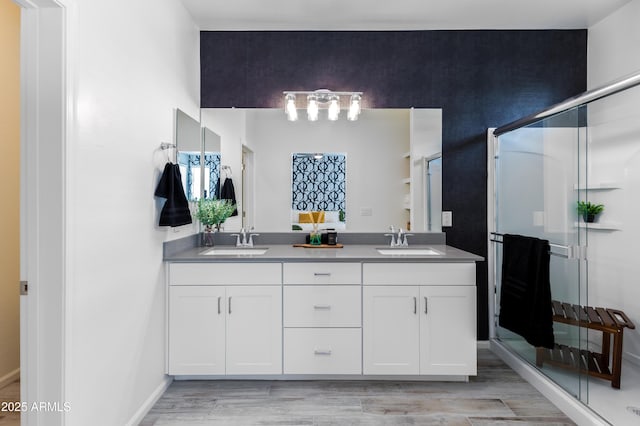 bathroom with vanity, wood-type flooring, and an enclosed shower