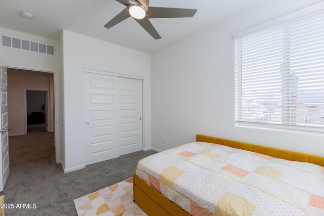 bedroom with ceiling fan, dark carpet, and a closet