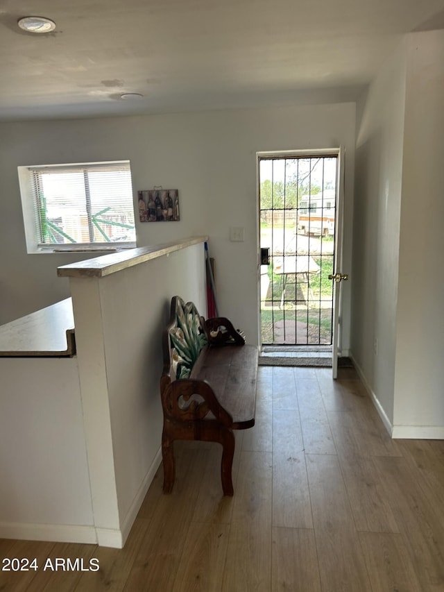 doorway to outside featuring wood finished floors and baseboards