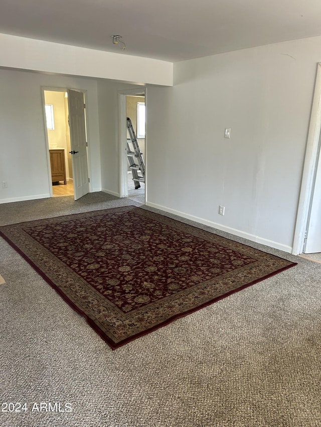 carpeted empty room featuring baseboards