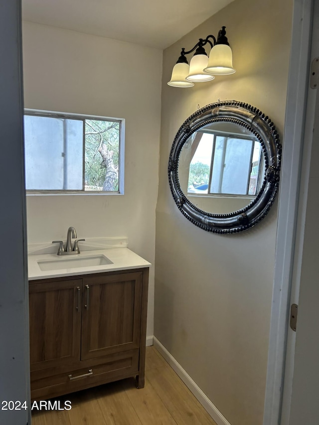 bathroom featuring a wealth of natural light, vanity, baseboards, and wood finished floors