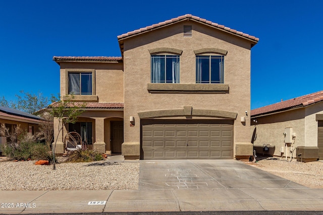 mediterranean / spanish home with stucco siding, a tiled roof, a garage, and concrete driveway