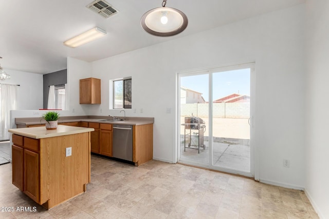 kitchen featuring light countertops, visible vents, dishwasher, baseboards, and a kitchen island