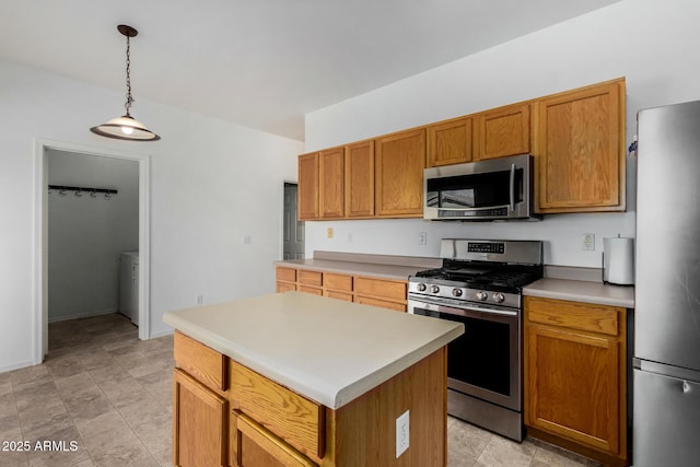kitchen featuring light countertops, a kitchen island, pendant lighting, appliances with stainless steel finishes, and brown cabinets