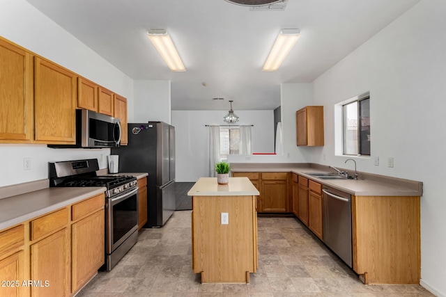 kitchen with light countertops, a sink, appliances with stainless steel finishes, a center island, and visible vents
