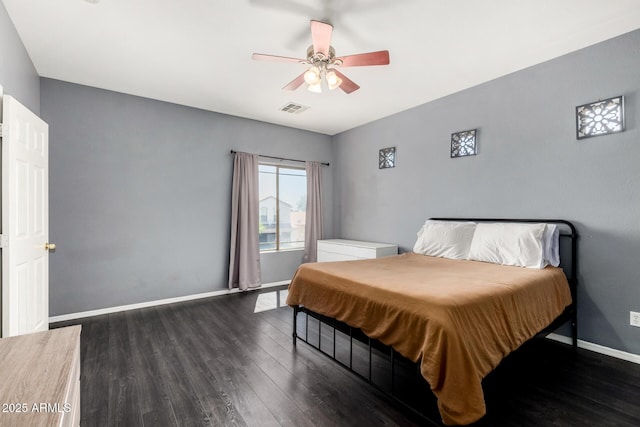 bedroom with baseboards, dark wood-style floors, visible vents, and ceiling fan