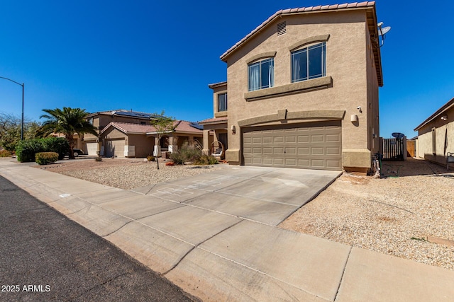 view of front facade with stucco siding, a gate, a garage, and concrete driveway