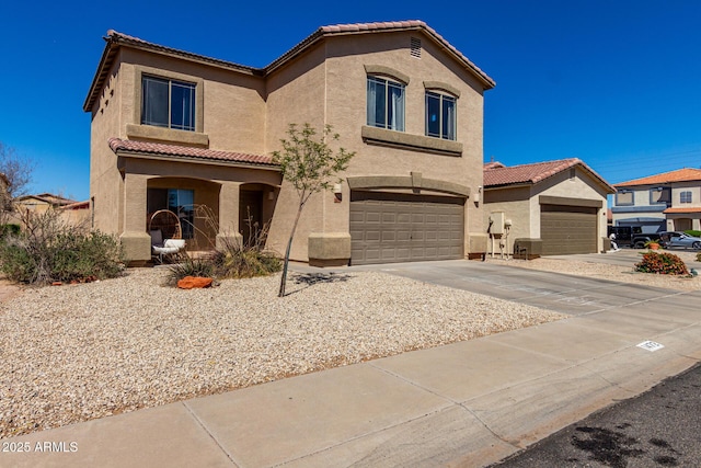 mediterranean / spanish-style home featuring driveway, stucco siding, an attached garage, and a tiled roof