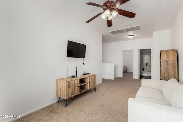 living area featuring light colored carpet, visible vents, baseboards, and a ceiling fan