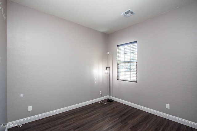 spare room featuring dark wood-type flooring, baseboards, and visible vents