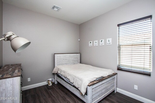 bedroom with dark wood-type flooring