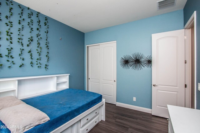 bedroom with baseboards, visible vents, a closet, and dark wood-style flooring