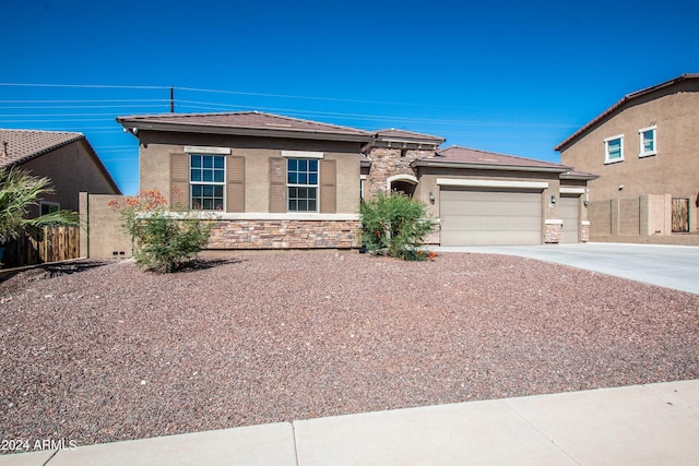 view of front of home featuring fence, stone siding, a garage, and concrete driveway