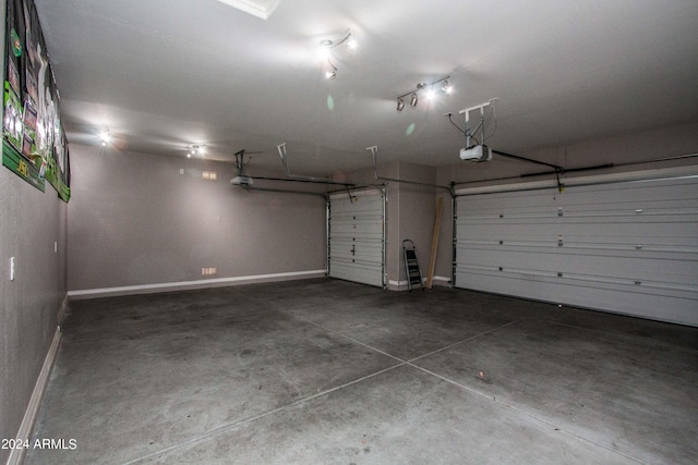 garage with baseboards and a garage door opener