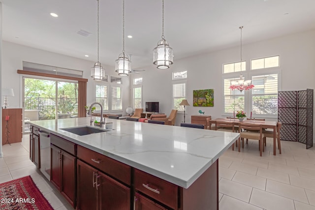 kitchen featuring a wealth of natural light, sink, an island with sink, and hanging light fixtures