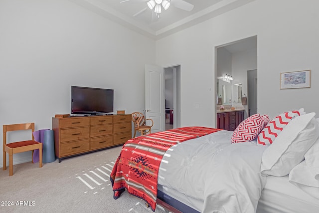 carpeted bedroom featuring a high ceiling, connected bathroom, and ceiling fan