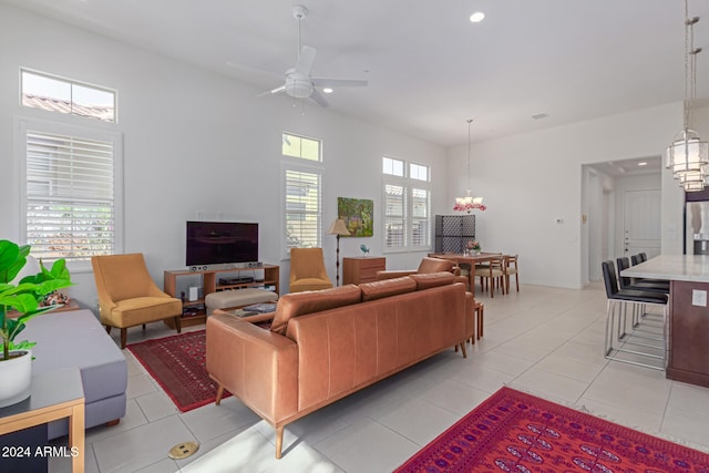 tiled living room featuring ceiling fan with notable chandelier