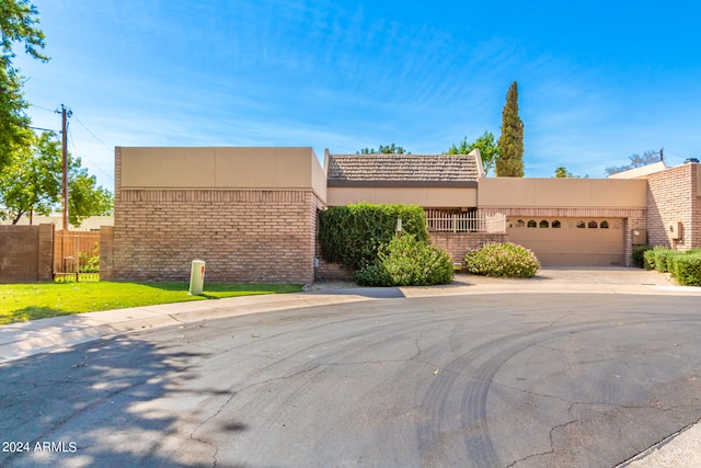 pueblo-style house with a front yard and a garage