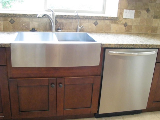 kitchen with a sink, tasteful backsplash, dishwasher, and light tile patterned flooring