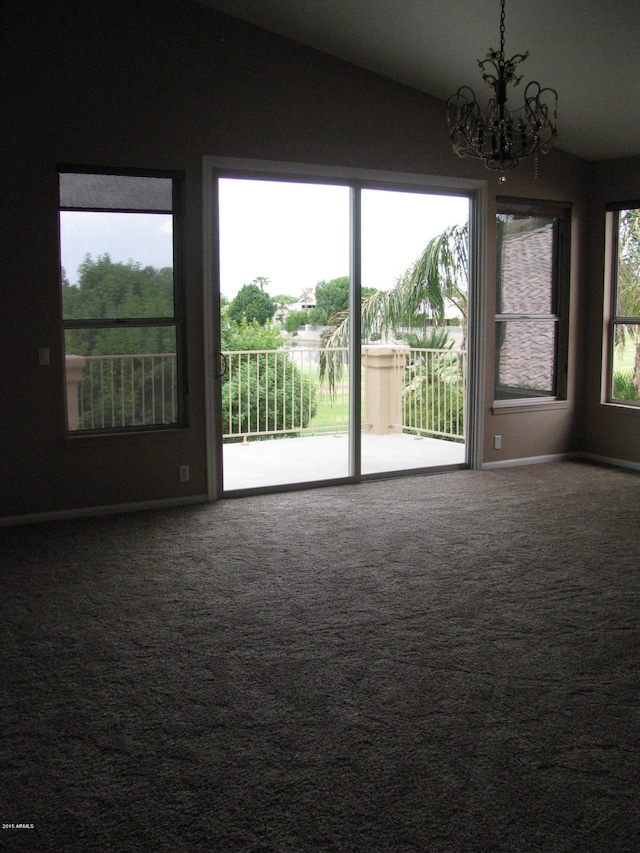 spare room featuring carpet floors, vaulted ceiling, and a notable chandelier