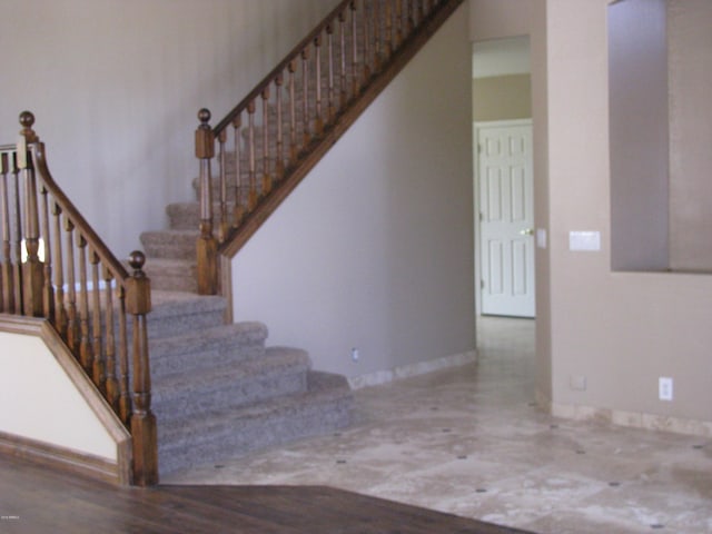 staircase with baseboards and wood finished floors