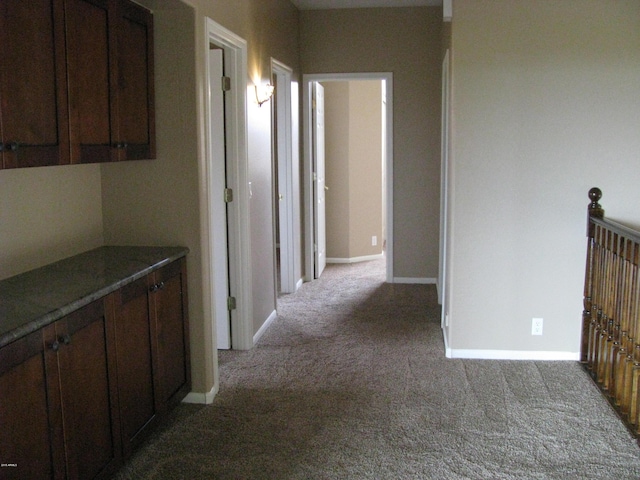 hall featuring light carpet and baseboards