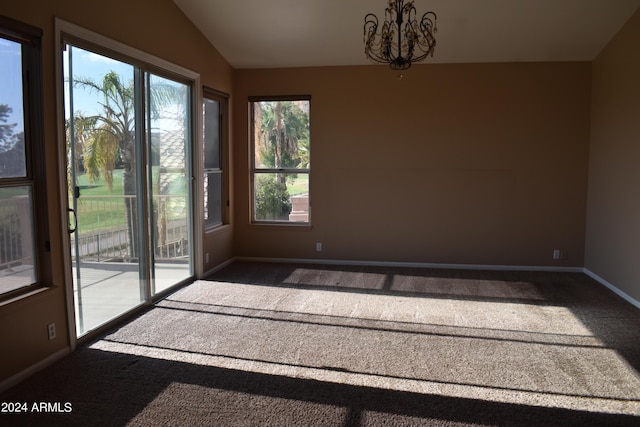 empty room featuring carpet floors, vaulted ceiling, baseboards, and an inviting chandelier