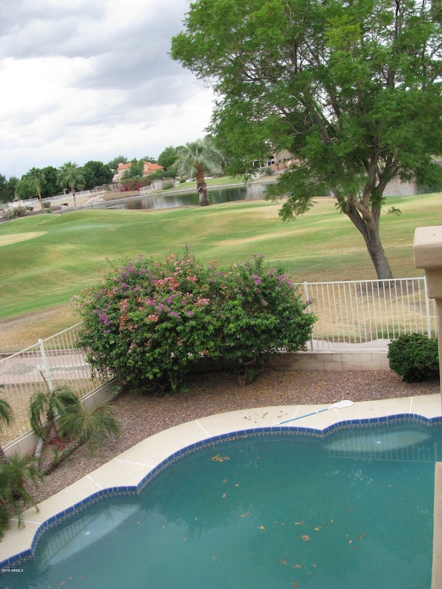 view of swimming pool with a water view and a yard