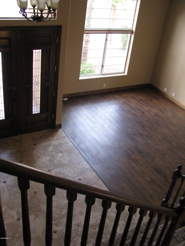 foyer entrance with a chandelier and dark wood-type flooring