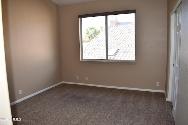 spare room featuring carpet and baseboards