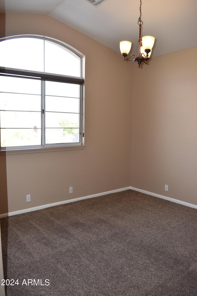 carpeted spare room featuring vaulted ceiling, visible vents, a notable chandelier, and baseboards