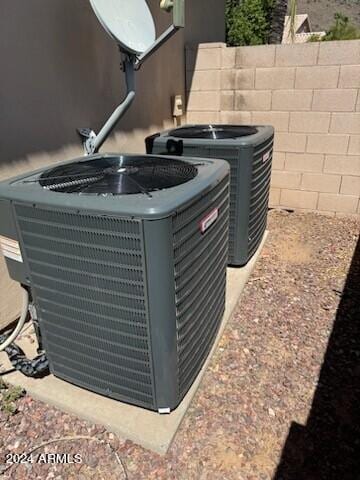 exterior details featuring central air condition unit, fence, and stucco siding