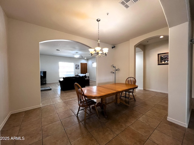 2427 W Desert Hills Estate Dr, Phoenix, AZ 85086 - tiled dining space featuring arched walkways, ceiling fan, a chandelier, and baseboards