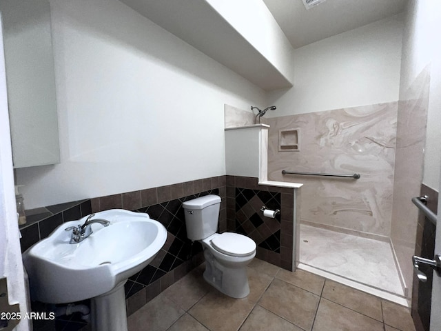 2427 W Desert Hills Estate Dr, Phoenix, AZ 85086 - bathroom with walk in shower, toilet, a wainscoted wall, tile walls, and tile patterned floors
