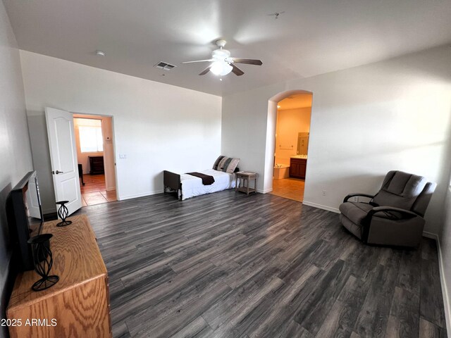 2427 W Desert Hills Estate Dr, Phoenix, AZ 85086 - unfurnished room featuring a ceiling fan, arched walkways, wood finished floors, and baseboards