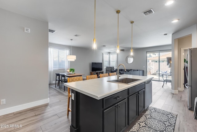 12211 W Hide Trl, Peoria, AZ 85383 - kitchen with appliances with stainless steel finishes, plenty of natural light, a kitchen island with sink, light wood-style flooring, and recessed lighting