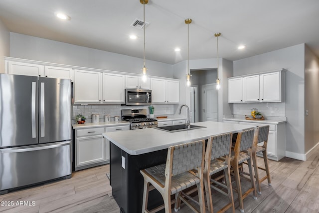 12211 W Hide Trl, Peoria, AZ 85383 - kitchen with appliances with stainless steel finishes, light countertops, a breakfast bar, light wood finished floors, and recessed lighting