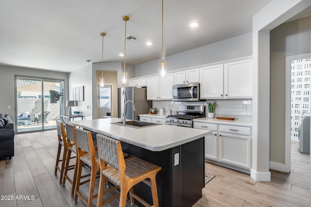 12211 W Hide Trl, Peoria, AZ 85383 - kitchen with stainless steel appliances, backsplash, light countertops, a breakfast bar, and an island with sink