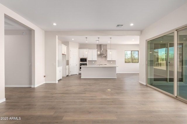 unfurnished living room with sink and light hardwood / wood-style floors