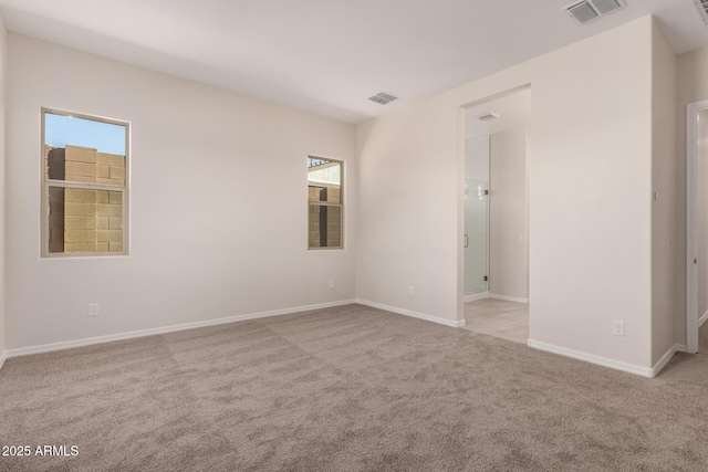 spare room featuring light carpet