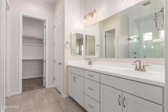 bathroom featuring a shower with door and vanity