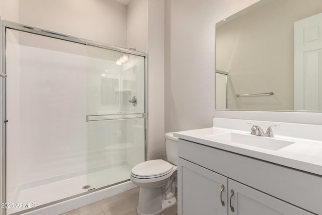 bathroom featuring vanity, toilet, an enclosed shower, and tile patterned flooring