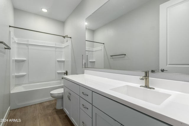 full bathroom with vanity, hardwood / wood-style flooring, shower / tub combination, and toilet