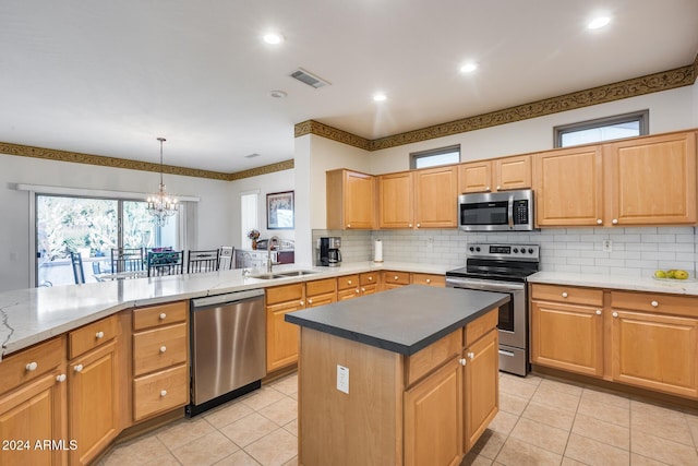 kitchen with stainless steel appliances, sink, decorative light fixtures, a chandelier, and a kitchen island