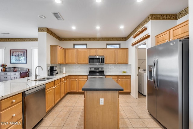 kitchen featuring a center island, sink, stainless steel appliances, backsplash, and light tile patterned floors